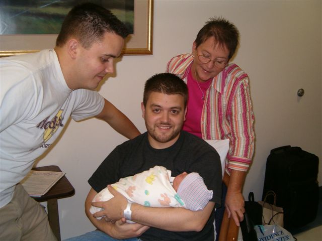 Uncle Andy and Grandma Donna are looking at Daddy holding me